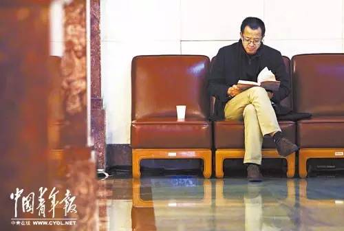 在北京人民大會堂開幕前，俞敏洪在角落里阅读